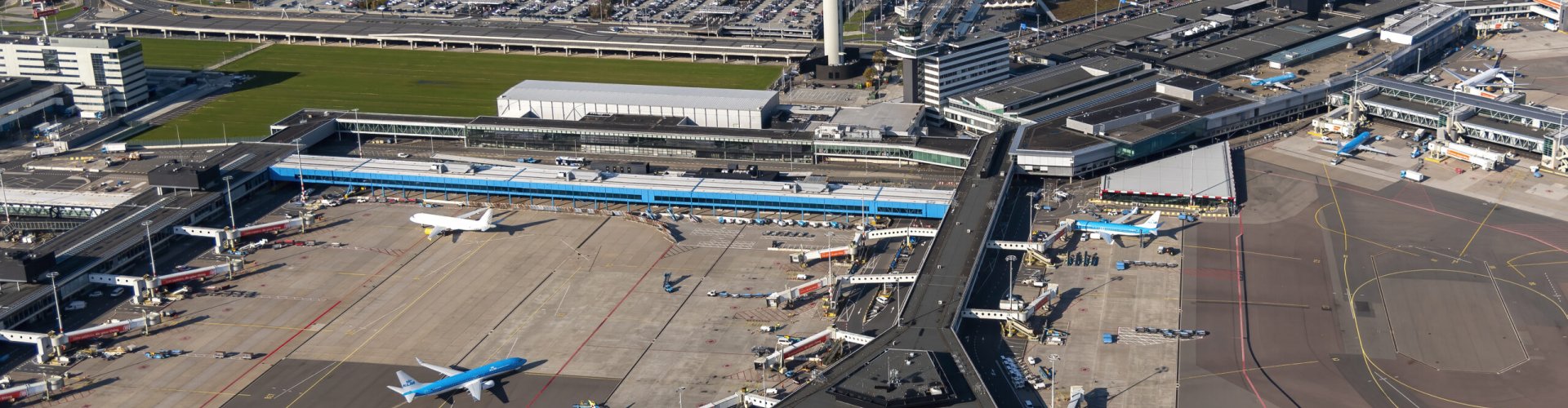 Sunset view of Schiphol Airport with planes and terminal glow